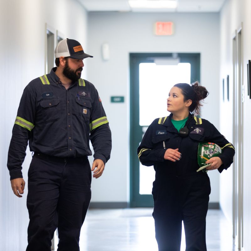 Photo of Two Nucor teammates walking down a hallway and talking