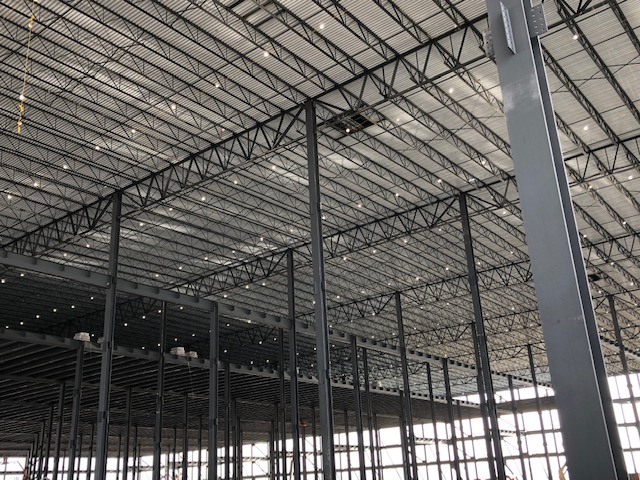 Building under construction showing steel joist, girders and structural steel columns and beams.