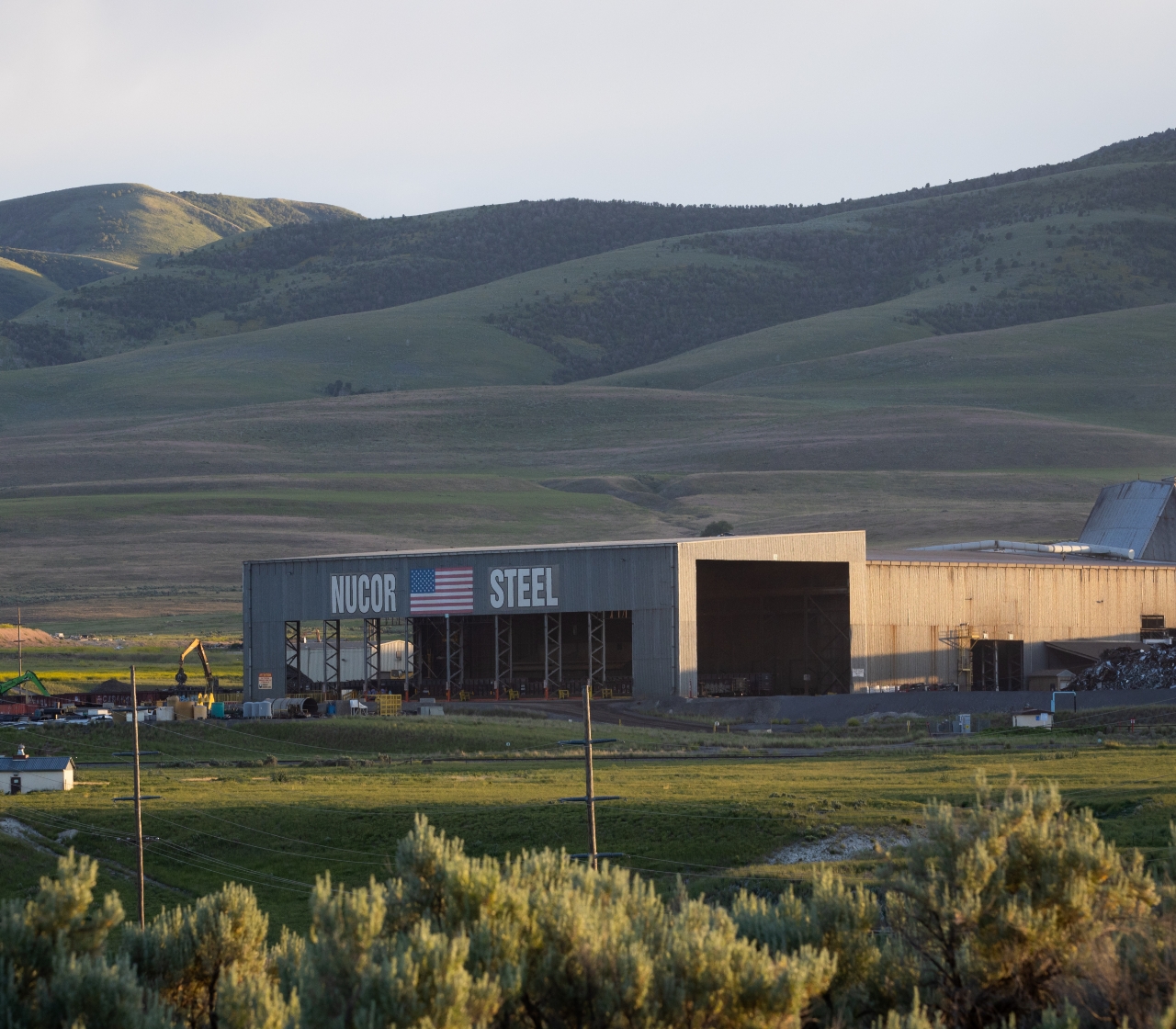 photo of the exterior of  Nucor Steel Utah in front of a beautiful mountain range