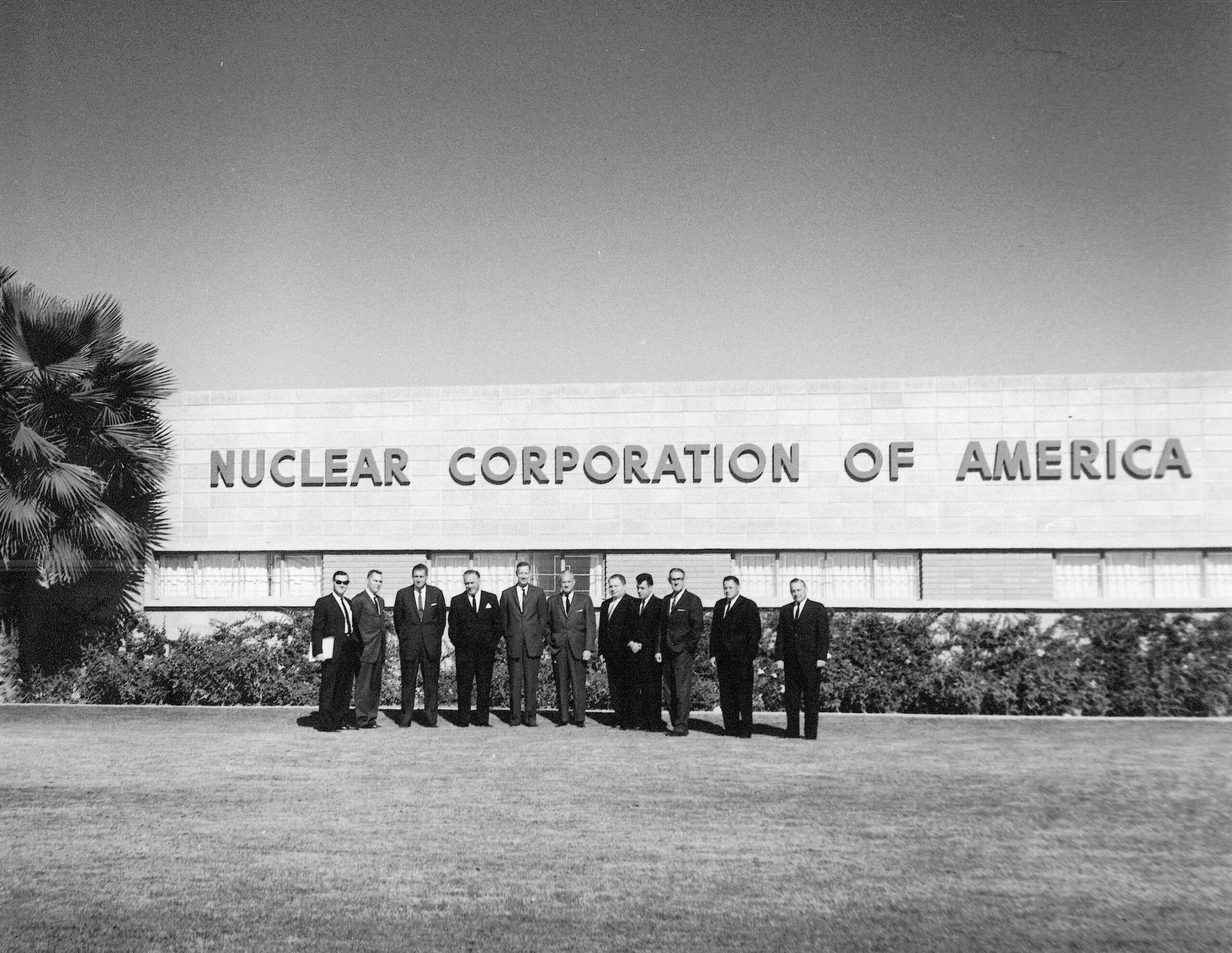 People standing outside of the Nuclear Corporation of America building