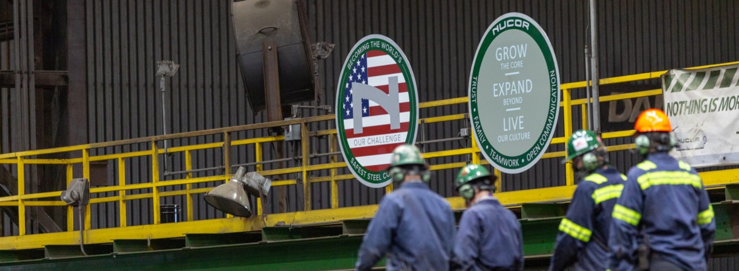 Photo of four Nucor teammates walking through a steel mill
